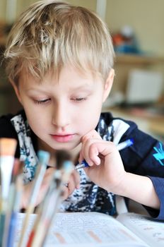 left-handed boy doing a home task at home 