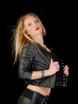 glamorous young woman in black leather jacket on black background, studio shot