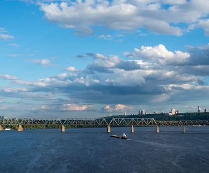 The barge floating in the blue Dnieper waters against the summer Kyiv landscape.