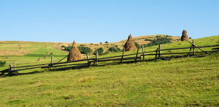 Wooden fence against the summer landscape in the Ukrainian Carpathian Mountains.