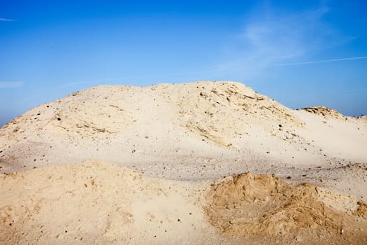 Pile of sand and blue sky over it.