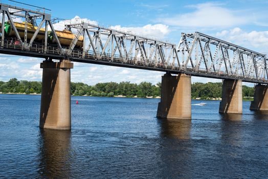 Petrivskiy railroad bridge in Kyiv across the Dnieper with freight train on it.