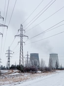 Electricity pylons, power lines and cooling towers of the cogeneration plant near Kyiv (Ukraine) in winter.