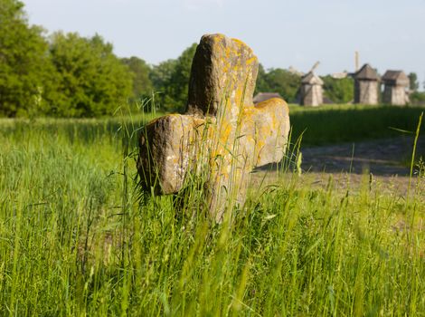 Old stone cross in Pyrohiv Museum of the Folk Architecture near Kyiv, Ukraine. Close up.