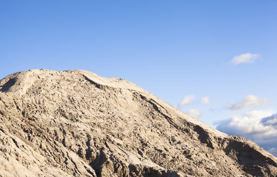 Pile of sand and blue sky over it.