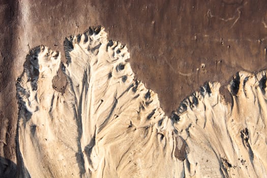 Sand surface after the rain with the relief formed by water currents.