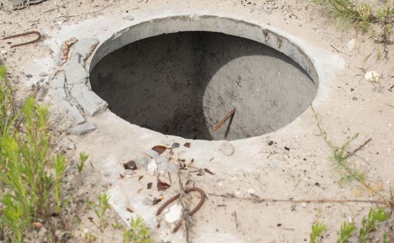 Manhole without cover in the concrete block.