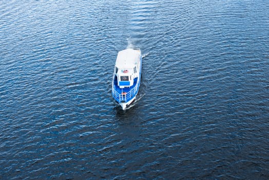 The boat floating in the blue Dnieper waters.