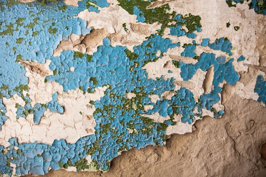Old wall with rich texture of the cracked blue and green paint