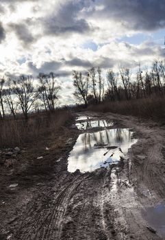 Mud and puddles on the dirt road.