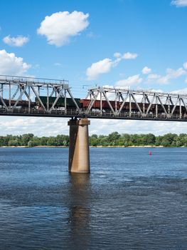 One of the piers supporting the railroad bridge across the Dnieper in Kyiv. Freight train passing across the bridge.
