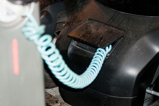 Close-up image of an electric car hooked up to an electricity charging station