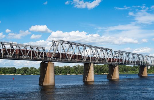 Petrivskiy railroad bridge in Kyiv across the Dnieper with freight train on it.