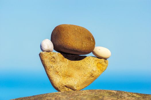 Balancing of round pebbles on the triangular stone