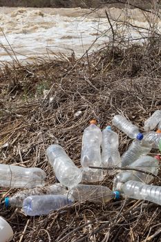 Beach pollution. Plastic bottles and other trash on river beach