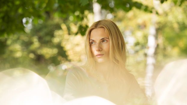 portrait of a beautiful young woman in a spring park. pictures in warm colors