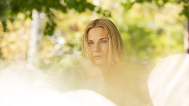 portrait of a beautiful young woman in a spring park. pictures in warm colors