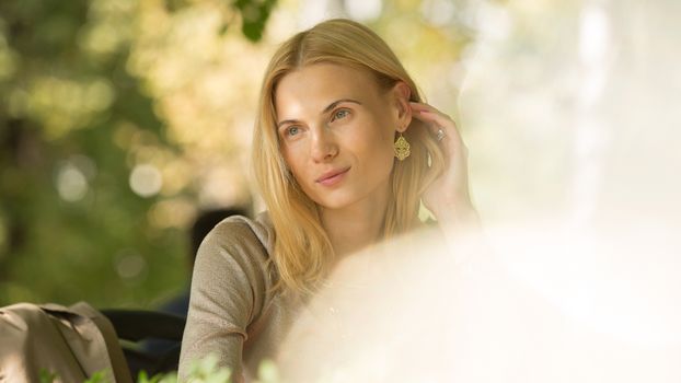 portrait of a beautiful young woman in a spring park. pictures in warm colors