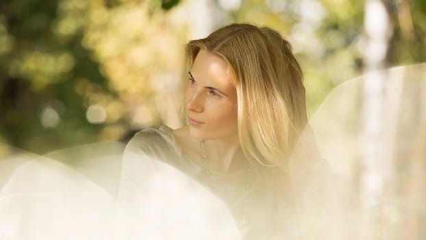 portrait of a beautiful young woman in a spring park. pictures in warm colors