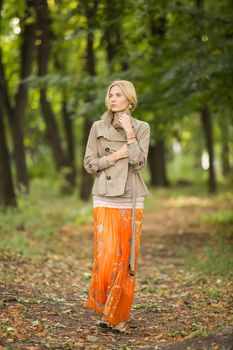 Young fashionable woman walking in spring park