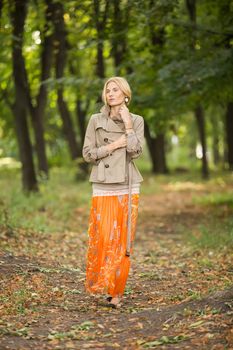 Young fashionable woman walking in spring park