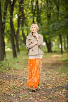 Young fashionable woman walking in spring park