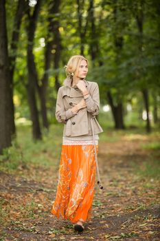 Young fashionable woman walking in spring park