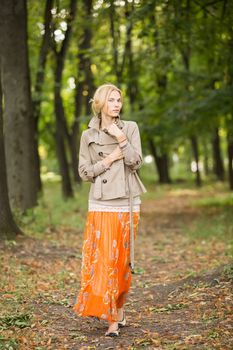 Young fashionable woman walking in spring park