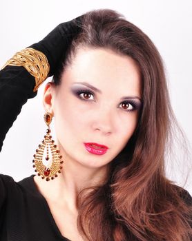 young beautiful dark-haired girl in extravagant earrings