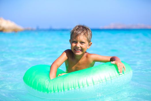 Happyboy playing on the inflatable rubber circle in the sea