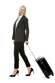blonde businesswoman smiling and carrying a suitcase