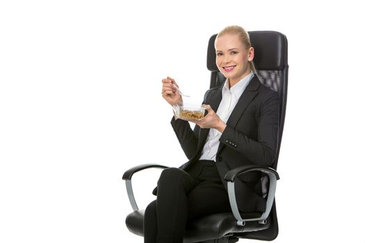 blonde businesswoman seated on a chair and having lunch
