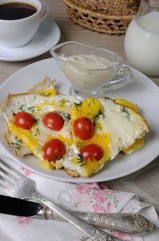 Scrambled eggs with cherry tomatoes, sliced baguette and a cup of coffee