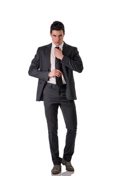 Full figure shot of handsome elegant young man with suit and neck-tie, isolated on white, looking at camera