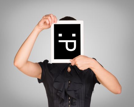 Girl in dress covered her face with tablet. On screen code smiley. Gray background