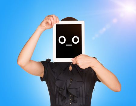 Young girl in black dress covered her face with tablet. On screen surprised smiley. Blue sky with sun light as backdrop