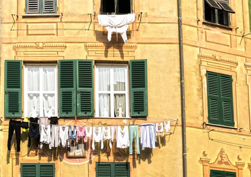 The laundry hanging in the sun on the outside of a house facade