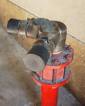 Emergency water pipe for the fires made of metal, painted in red below.                               