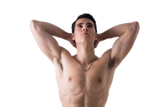 Handsome, fit young man standing shirtless isolated on white, hands behind his head, looking up