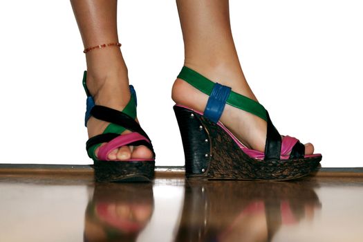 Female legs in colorful high-heeled sandals