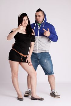 Young couple in rapper clothes posing in the studio