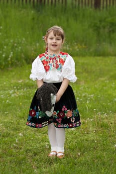 Little girl playing with tailstock on a meadow