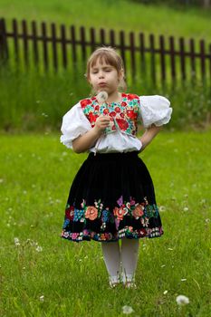 Little girl in traditional costume, with flower in hand