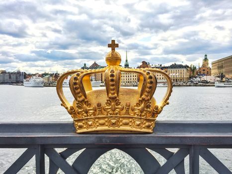 Swedish royal crown on a bridge, view over Gamla Stan. Stockholm, Sweden.