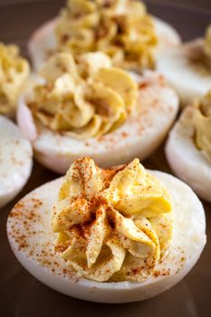 Deviled eggs on a plate with the sun shinning on them from a kitchen window.