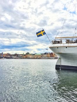 White ship with Swedish flag and view over Gamla Stan. Stockholm, Sweden.