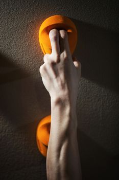 Cropped view of rock climber gripping handhold with two fingers