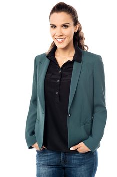 Confident female executive with hands in pockets.