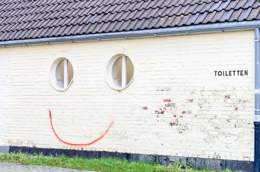 Fun, spray painted smiley on a house wall.