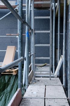 Steel scaffold next to house wall with polystyrene.